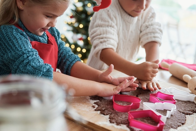 Enfants découpant des biscuits en pain d'épice