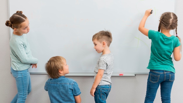 Enfants écrivant sur un tableau blanc