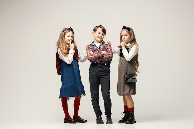 Enfants élégants mignons sur mur blanc