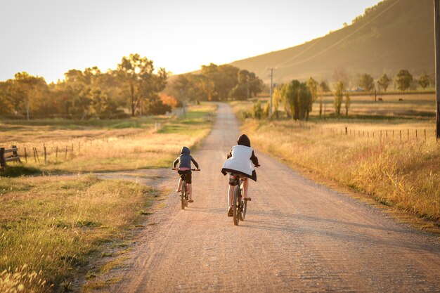 Enfants faisant du vélo sur un chemin de campagne éloigné