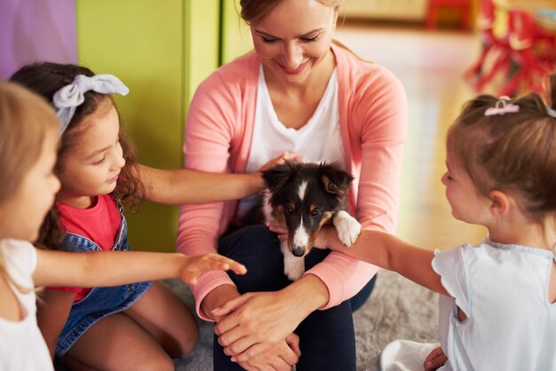 Enfants heureux caressant un chien mignon