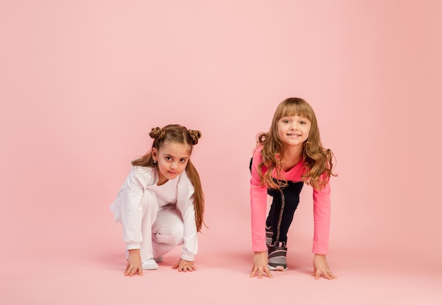 Enfants heureux isolés sur le mur de studio rose corail