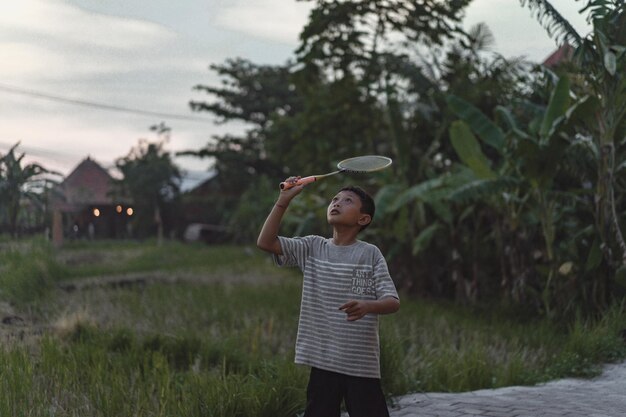 enfants indonésiens heureux jouant au badminton.