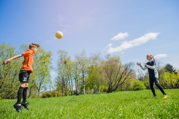 Enfants jouant au football dans le parc