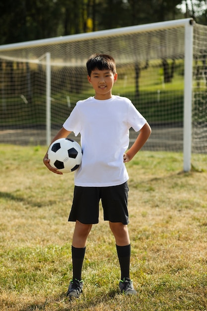 Photo gratuite enfants jouant au football supervisés par un entraîneur de football