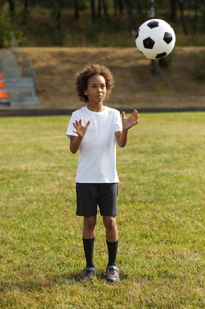 Photo gratuite enfants jouant au football supervisés par un entraîneur de football