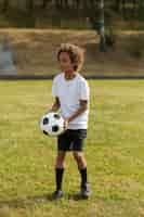 Photo gratuite enfants jouant au football supervisés par un entraîneur de football