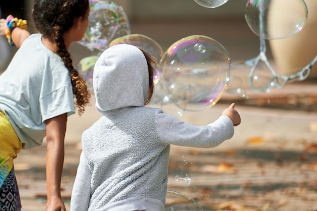 Photo gratuite enfants jouant avec des bulles de savon