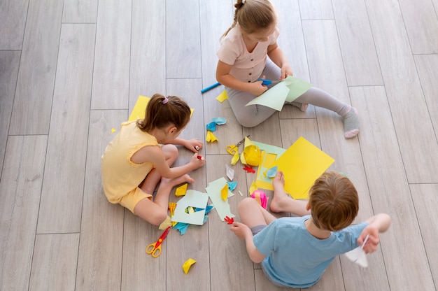 Enfants jouant avec du papier plein coup