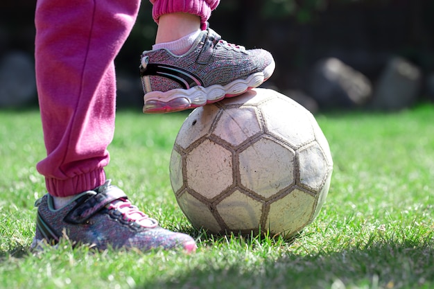 Les enfants jouent au football sur l'herbe, gardent leur pied sur le ballon. Le concept d'un jeu d'équipe.