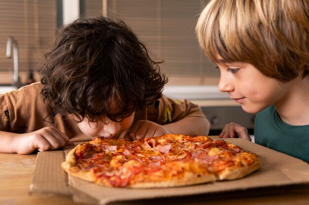 Enfants mangeant des pizzas ensemble