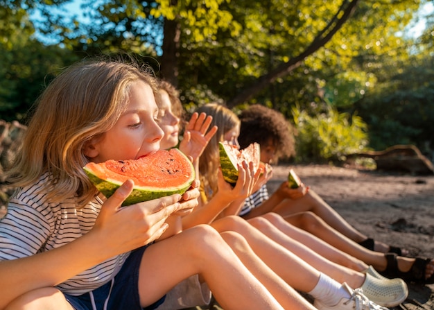 Enfants mangeant la vue de côté de pastèque