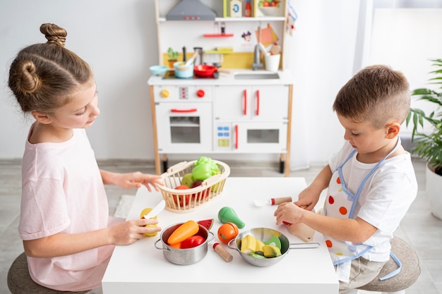 Enfants mignons jouant avec un jeu de cuisine