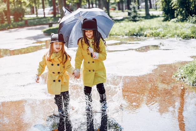 Enfants mignons plaiyng un jour de pluie