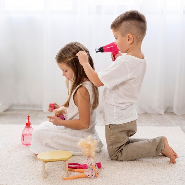 Enfants non binaires jouant ensemble à un jeu de salon de beauté