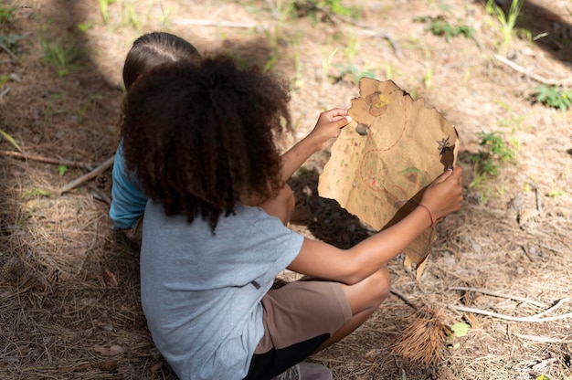 Photo gratuite enfants participant à une chasse au trésor dans une forêt