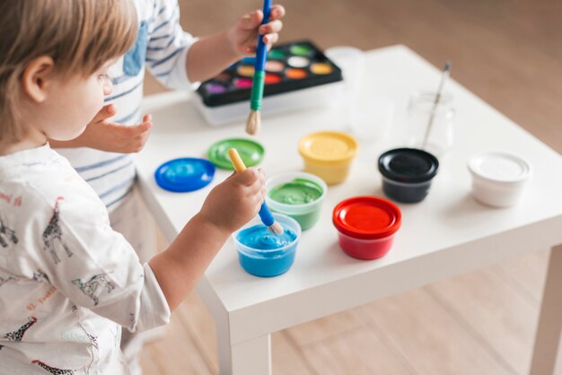 Enfants peignant ensemble à la maison