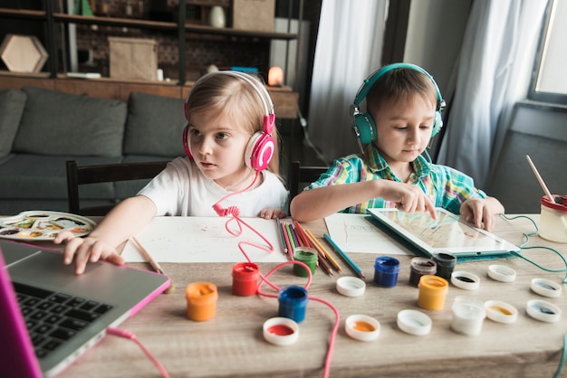 Enfants peignant et utilisant un ordinateur