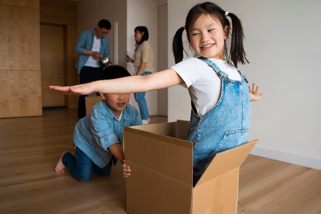Enfants de plan moyen jouant avec la boîte