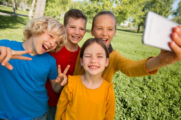 Des enfants à plan moyen prenant un selfie