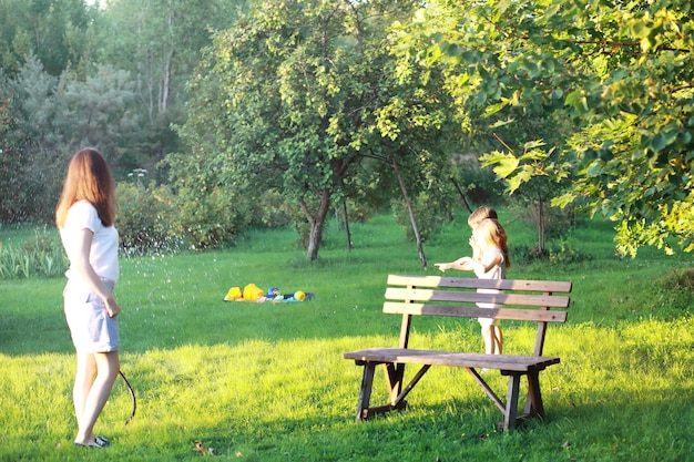 Enfants en promenade en été. les enfants s'adonnent à la campagne. rires et projections d'eau.