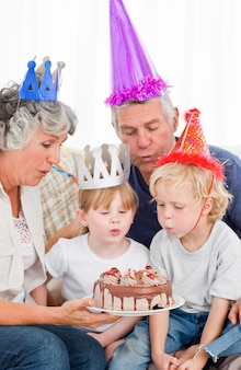 Enfants qui soufflent sur le gâteau d'anniversaire