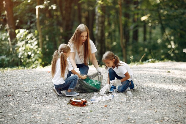 Enfants ramassent les ordures dans des sacs à ordures dans le parc