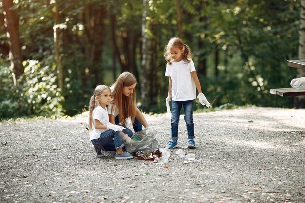 Enfants ramassent les ordures dans des sacs à ordures dans le parc