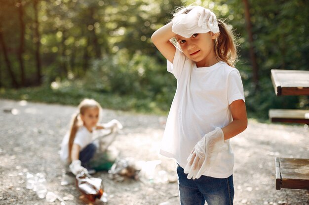 Enfants ramassent les ordures dans des sacs à ordures dans le parc