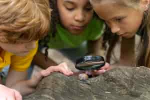 Photo gratuite enfants regardant ensemble un escargot
