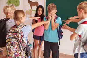 Photo gratuite les enfants rient de leur camarade de classe