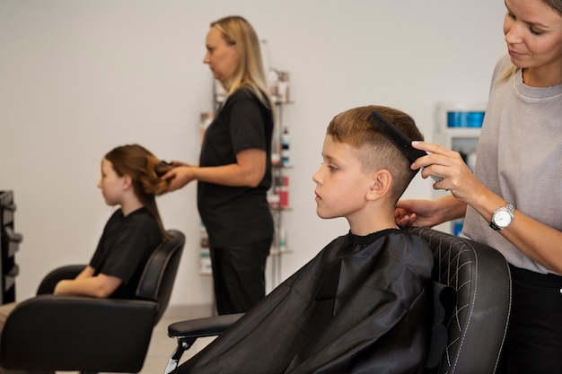 Enfants se faisant couper les cheveux au salon vue latérale