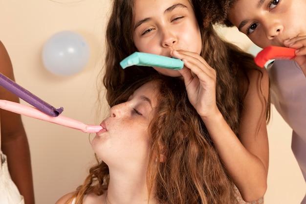 Enfants avec des sifflets de fête se bouchent