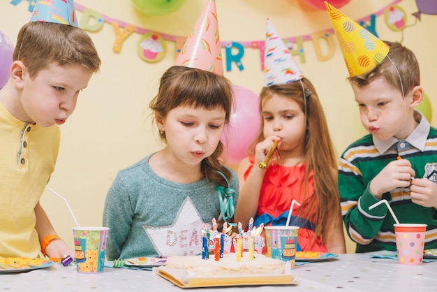 Enfants soufflant des bougies sur le gâteau