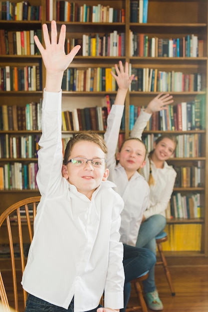 Enfants souriants, mettre les mains dans la bibliothèque