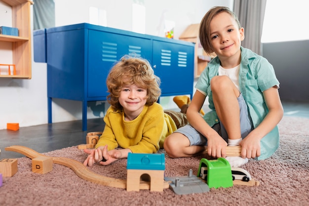 Photo gratuite enfants souriants plein coup jouant avec le train