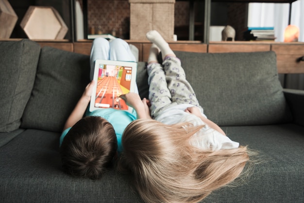 Enfants avec tablette sur canapé