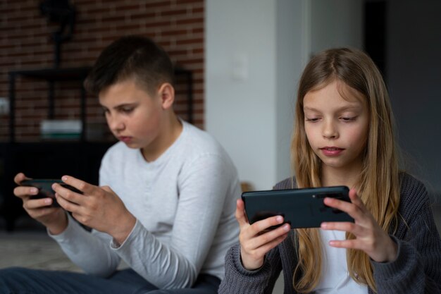 Enfants de tir moyen avec des appareils