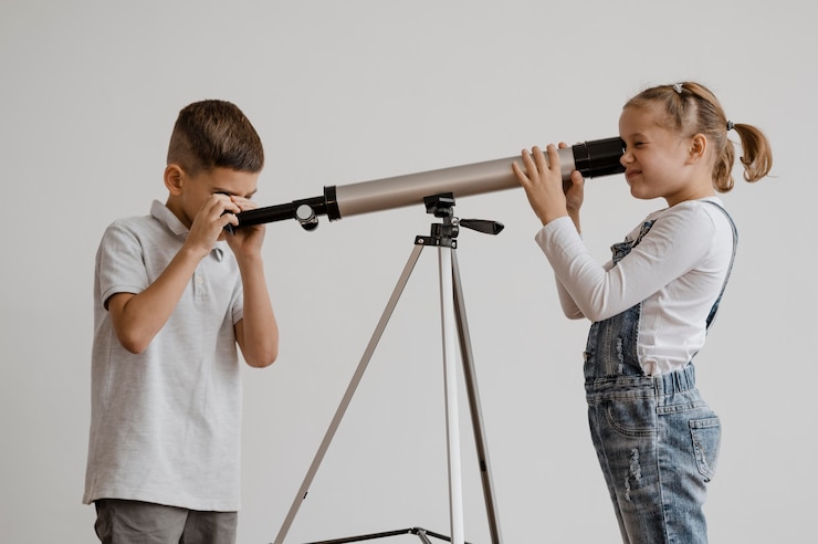 Photo gratuit enfants utilisant un télescope en classe