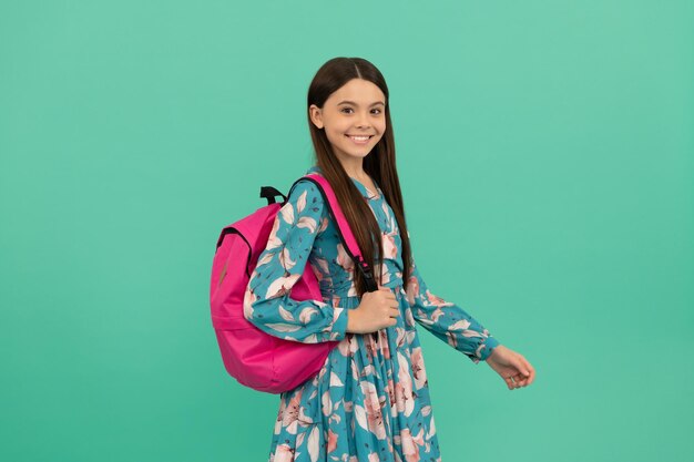 Enfin le 1er septembre. enfance heureuse. enfant avec cartable. une adolescente heureuse porte un sac à dos. retour à l'école. journée du savoir. concept d'éducation. beau gosse aux cheveux longs sur fond bleu.