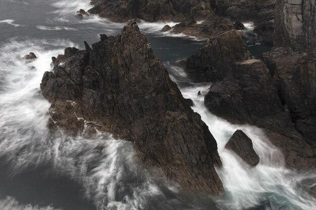 D'énormes rochers au milieu d'une mer capturés par une journée nuageuse