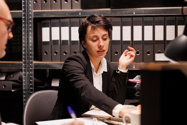 Photo gratuite l'enquêteur répond à un appel téléphonique fixe dans la salle d'archives.