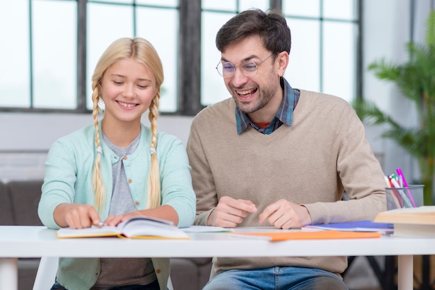 Photo gratuite enseignant et jeune étudiant s'amusant