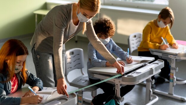 Enseignant mesurant la distance sociale entre les bancs d'école pendant la pandémie