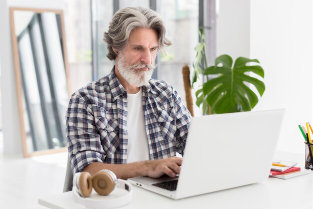 Enseignant à mi-parcours restant au bureau à l'aide d'un ordinateur portable