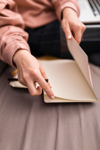 Enseignante à l'aide de papier de l'ordre du jour pendant la classe en ligne