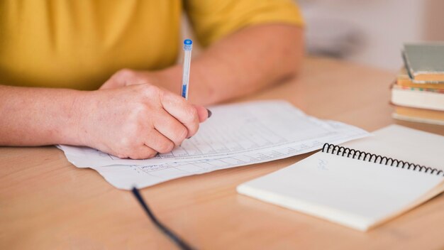 Enseignante au bureau écrit gros plan