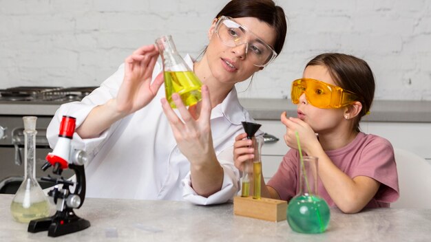 Enseignante et fille faisant des expériences scientifiques