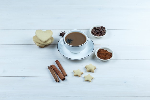 Ensemble de biscuits, épices, grains de café, café moulu et café dans une tasse sur un fond en bois. vue grand angle.