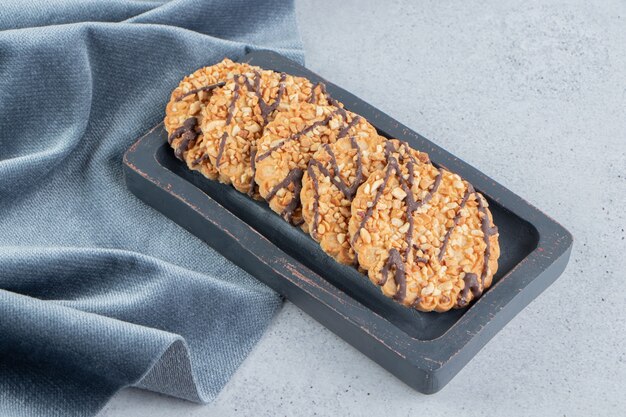 Ensemble de biscuits sur une planche de bois à côté de la nappe sur fond de marbre.